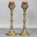 A pair of Gothic brass candlesticks,