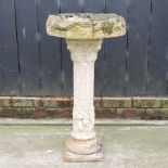 A reconstituted stone bird bath,