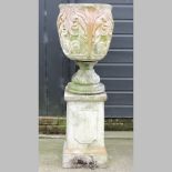 A reconstituted stone urn, on a pedestal,