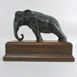 A bronzed elephant on a leather base,
