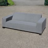 An all-weather grey upholstered garden sofa by Sunbrella,