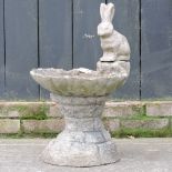 A reconstituted stone rabbit bird bath,