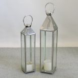 A modern chrome garden lantern, together with another smaller,