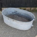 An oval galvanized metal garden trough,