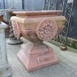 A red terracotta garden urn, on stand,