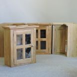 A pair of light oak kitchen cupboards, together with a pair of glazed hanging cabinets,