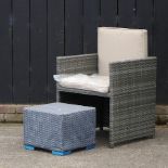A single grey rattan garden chair, together with a small coffee table,