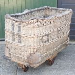 An early 20th century wicker GPO mail trolley on wheels,