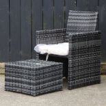 A single black rattan garden chair, together with a small coffee table,