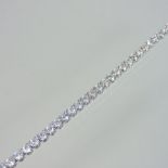 A diamond set tennis bracelet, set with a single row of forty-six diamonds, with a hinged clasp,