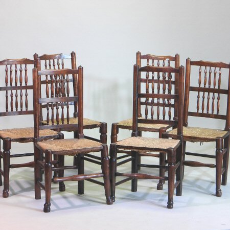 A harlequin set of six 19th century ash and elm spindle back dining chairs, with rush seats,