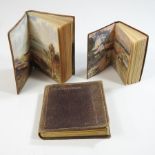 A collection of three early 20th century miniature leather bound books,