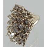 A large 14 carat gold diamond cluster ring, of asymmetric form, set with twenty-six diamonds,