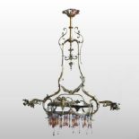 An early 20th century brass ceiling light, with ornate scrolled decoration, flanked by twin sconces,
