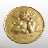 A 14 carat gold medallion, relief decorated with a Michelangelo cherub, dated 19 October 1932, 4.