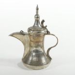 An Omani white metal Dallah coffee pot, with a hinged lid, stamped 925,