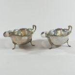 A pair of early 20th century silver sauce boats, each of helmet shape, on cabriole legs,