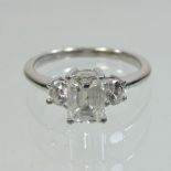 An 18 carat gold emerald cut three stone diamond ring, approximately 1.