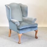 An early 20th century blue upholstered wing armchair