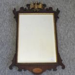 A George III style fret carved parcel gilt mahogany wall mirror,