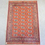A Bokhara style carpet, on a red ground,
