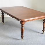 A Victorian style mahogany dining table, on reeded legs,