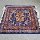 A Turkish style rug, with a central medallion and geometric design, on a blue ground,