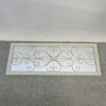 A green wall mirror, with heart design,