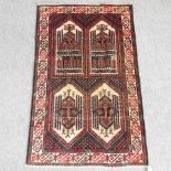 An oriental woollen carpet, with four lozenges and geometric designs, on a red ground,