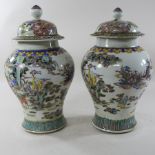 A pair of Chinese Canton porcelain ginger jars and covers, decorated with figures,