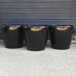 A set of three black circular garden pots,