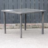 A rattan garden table, with a glass top,
