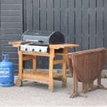 A barbecue, gas, 133cm, together with a teak garden table,