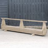 A vintage wooden animal feed trough,