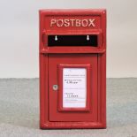 A red painted metal postbox,