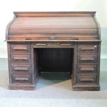 An early 20th century oak tambour top pedestal desk,