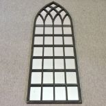 A black painted iron framed gothic style wall mirror,