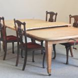 An Edwardian satinwood extending dining table, with three additional leaves and a winder,