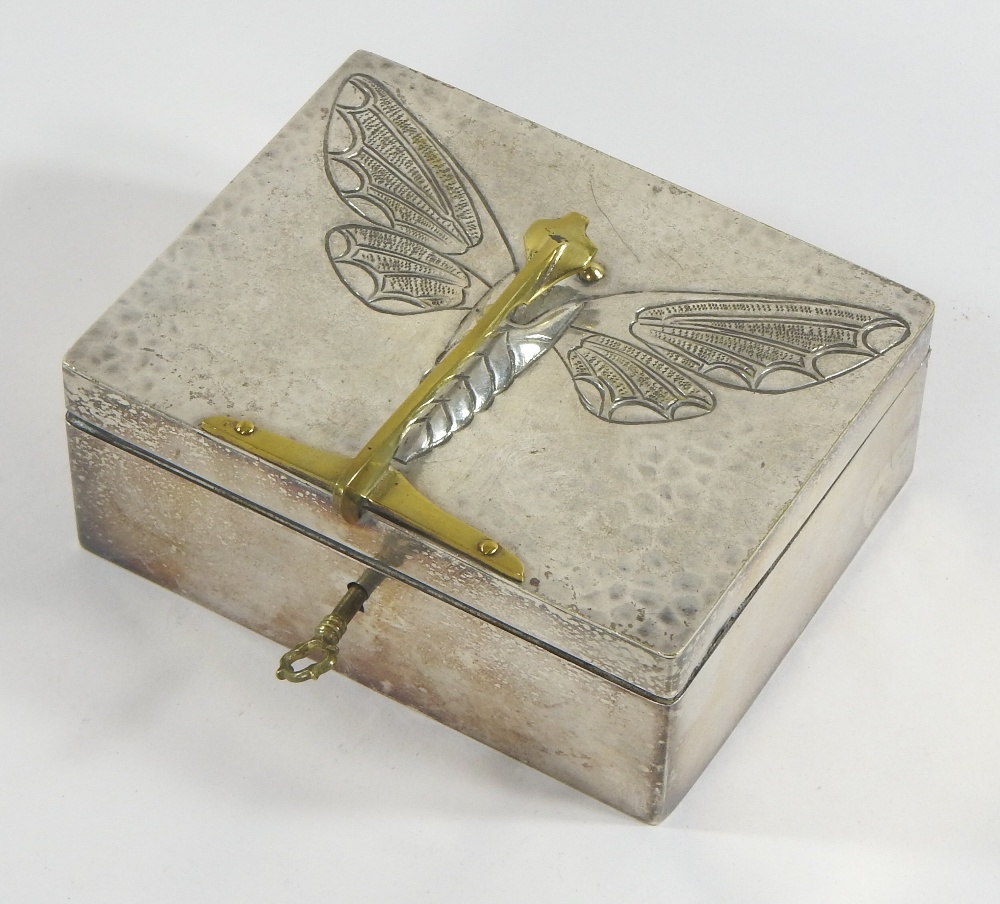 An early 20th century pewter box and cover, decorated in relief with a butterfly,