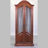 A French style walnut armoire, with glazed doors, fitted with drawers and shelves,