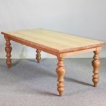A handmade light oak dining table, on turned legs,