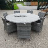 A grey rattan circular garden table, fitted with an ice bucket,