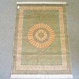 A persian style rug, with a central medallion, on a green ground,