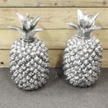 A pair of large silver painted pineapples,