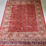 A Bokhara style carpet, with rows of medallions on a red ground,
