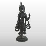 An Indian bronze figure of a deity, shown standing, on a circular base,
