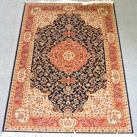 A Keshan style carpet, with a central medallion and foliate design, on a blue ground,