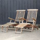 A pair of teak sun loungers