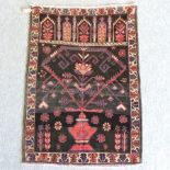 A Persian woollen prayer rug, with geometric designs, on a black ground,