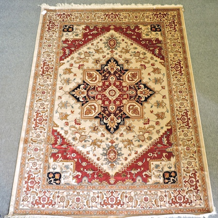 A Heriz style carpet, with a central medallion, on a beige ground,